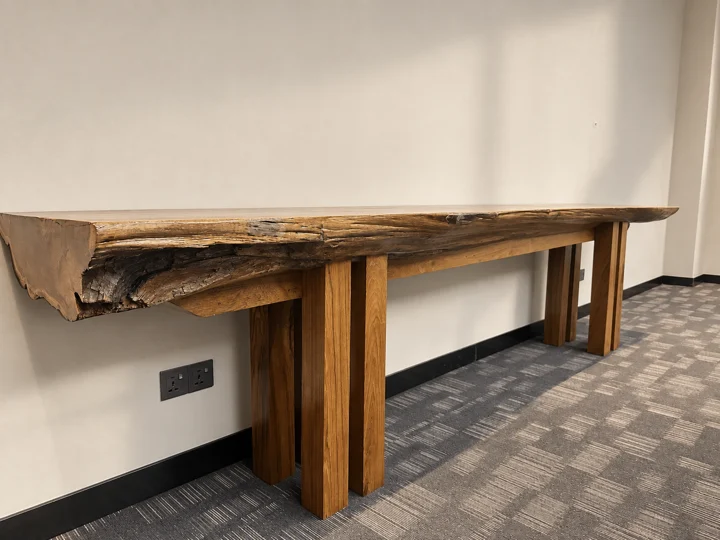 A substantial live-edge hardwood console with its natural grain and irregular edge